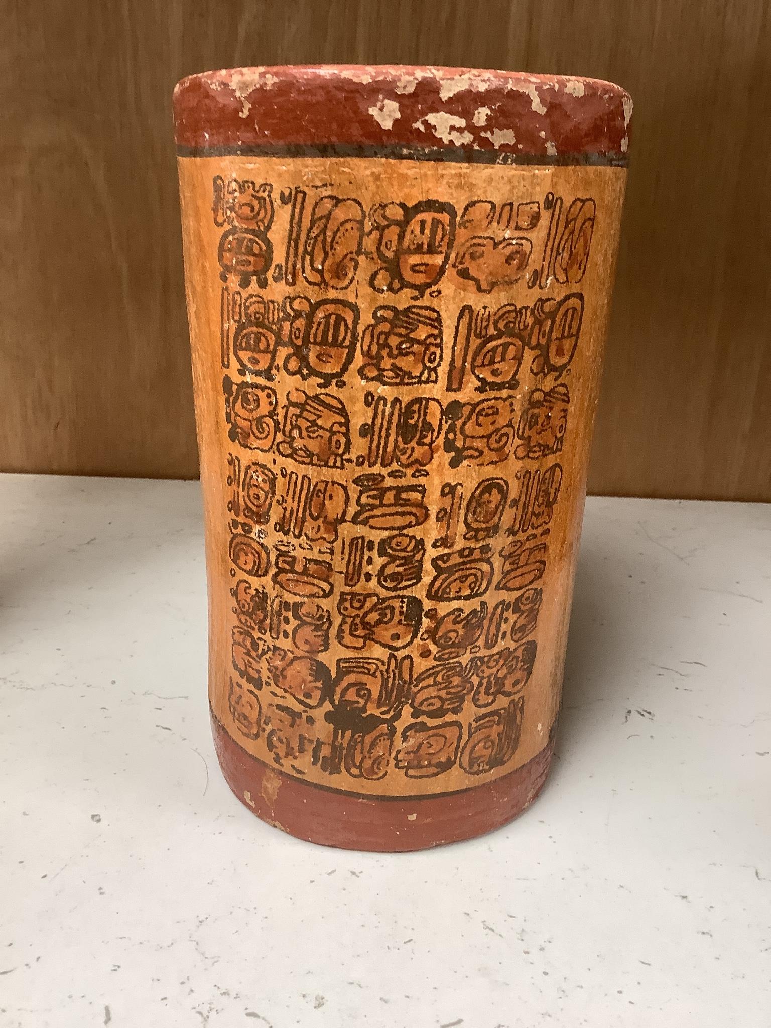 A Mayan pigment painted terracotta cylindrical vessel, possibly 7th-9th century AD., 17.2cm high, under a glass dome with revolving wood stand, total height 26cm